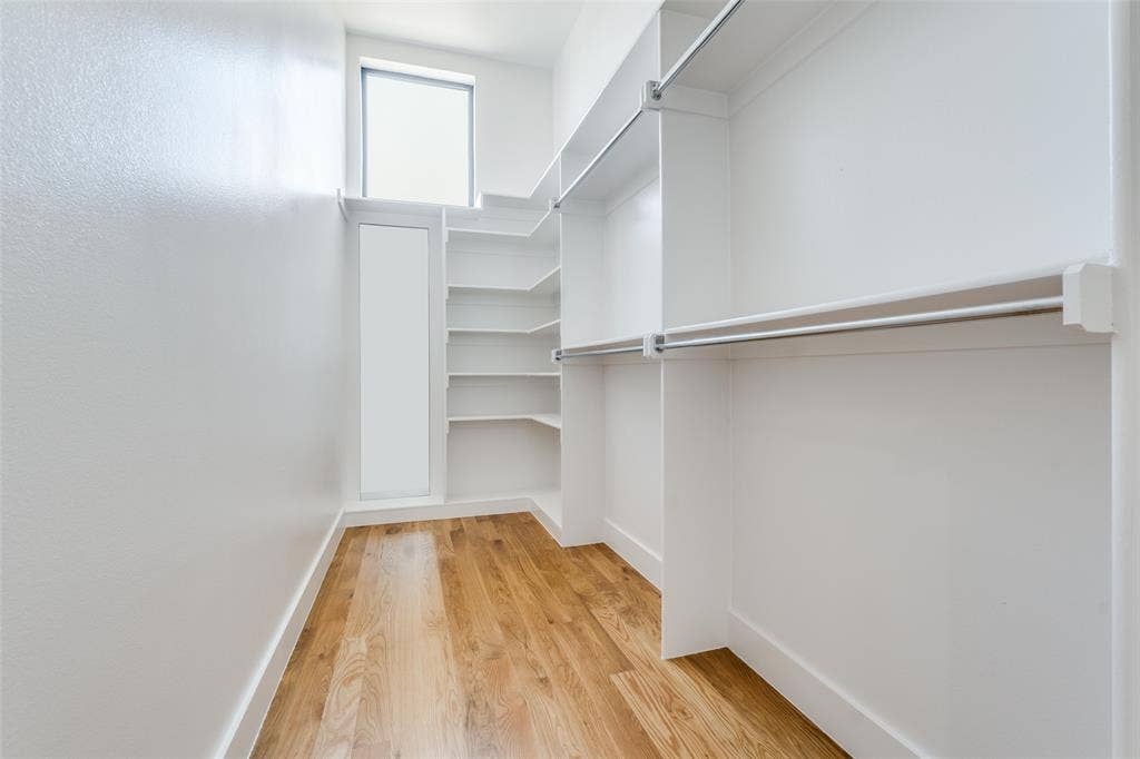 805 Pavillion Street, #103, Dallas, TX 75204 Spacious walk-in closet featuring wood-finish flooring, built-in shelving, and hanging rods