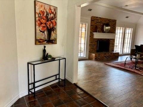3713 San Juan Circle, Plano, TX 75023 Brick fireplace with a white mantel, arched doorways, and tile flooring