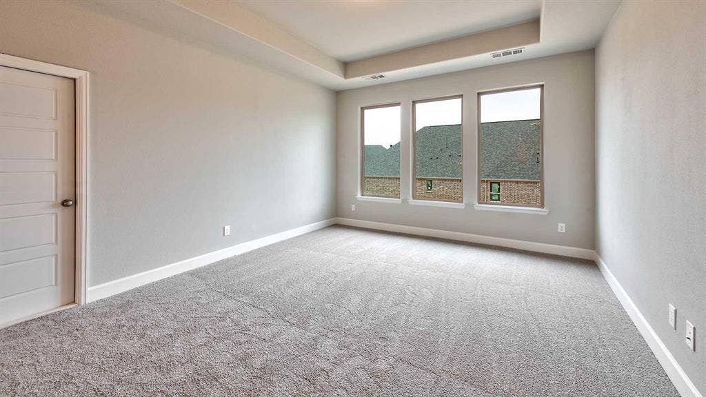 4237 Capstone Road, Midlothian, TX 76065 Tray ceiling, recessed lighting, neutral wall paint, gray carpeting, and modern paneled door