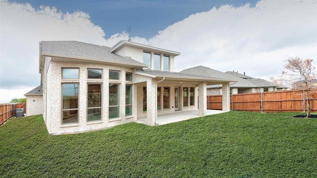 4237 Capstone Road, Midlothian, TX 76065 Expansive backyard with a manicured lawn, full privacy fencing, covered patio, and large windows