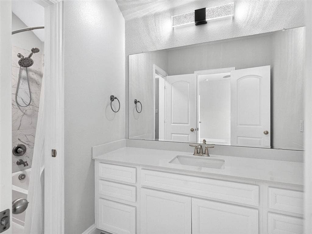 6504 Dynamite Drive, McKinney, TX 75070 White vanity with integrated sink, brushed nickel faucet, and extensive countertop