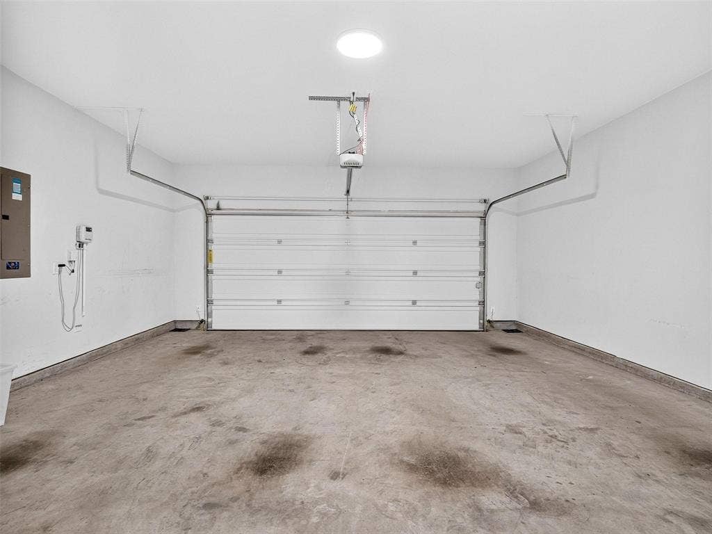 6504 Dynamite Drive, McKinney, TX 75070 Garage space with concrete flooring, overhead lighting, and an automatic garage door opener