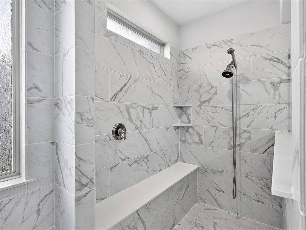 6504 Dynamite Drive, McKinney, TX 75070 Walk-in shower with large format tile, built-in bench, dual shower heads, and an integrated shelf