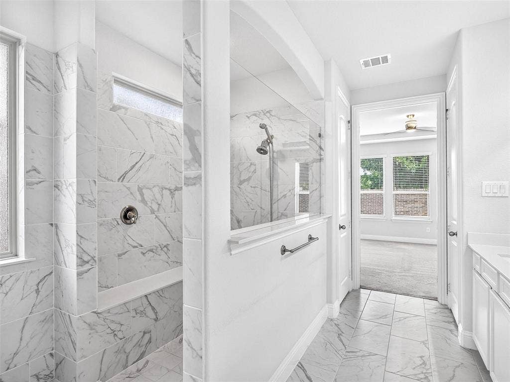 6504 Dynamite Drive, McKinney, TX 75070 Walk-in shower with full-height tile surround, integrated shower bench, and a glass partition