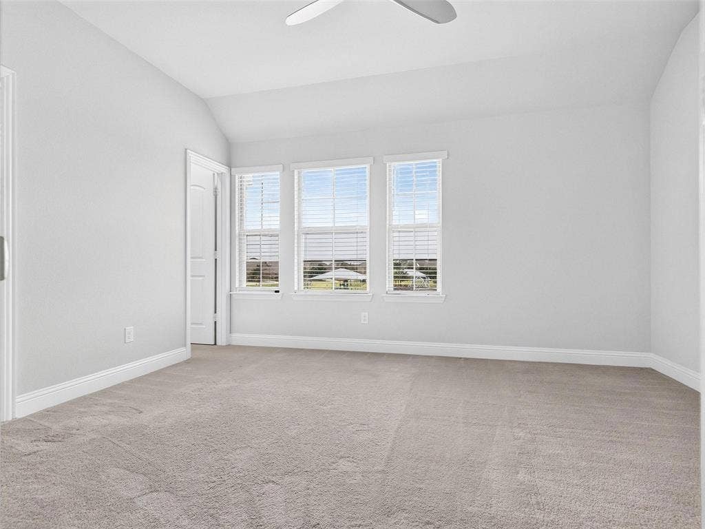 6504 Dynamite Drive, McKinney, TX 75070 Vaulted ceiling, ceiling fan, triple windows, white trim, and light-toned carpeting