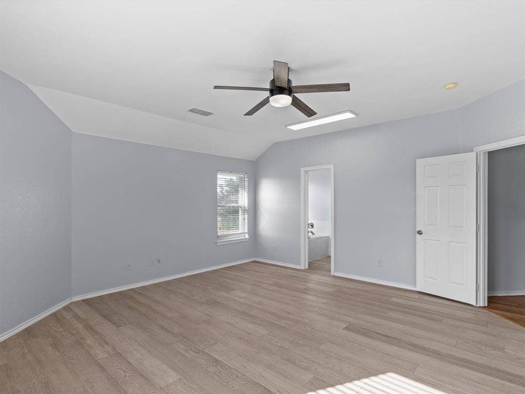 7302 San Carlos Drive, Rowlett, TX 75089 Vaulted ceiling with a ceiling fan, wood-finish flooring, and a window with blinds