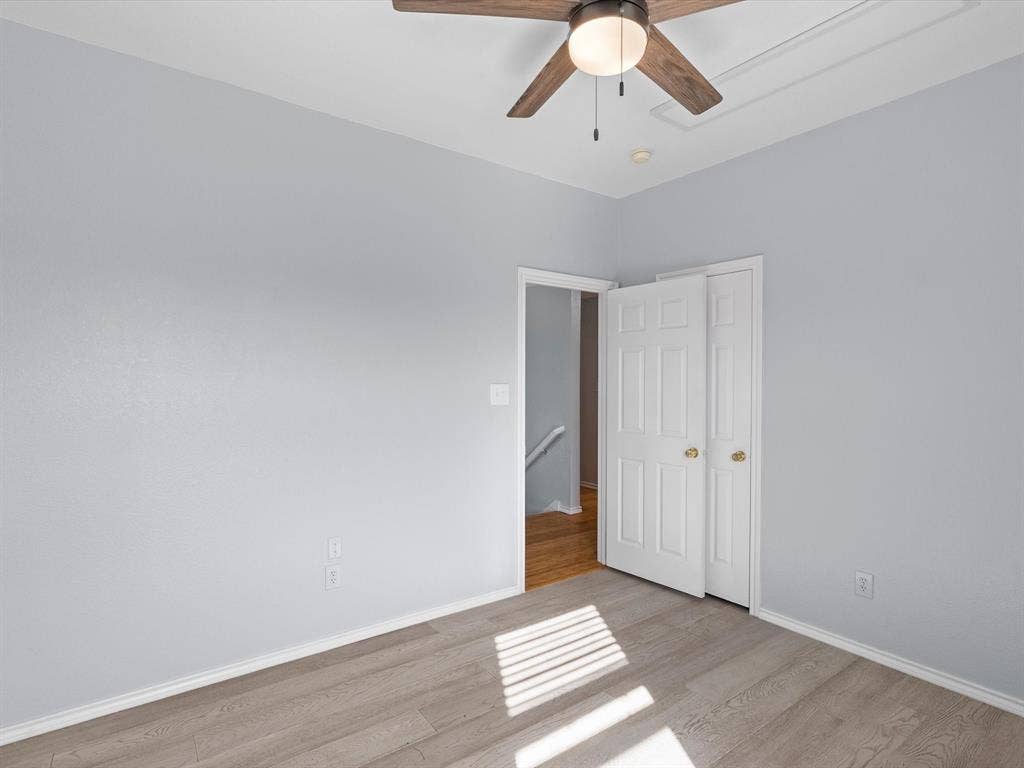 7302 San Carlos Drive, Rowlett, TX 75089 Light wood-finish flooring, a ceiling fan with integrated lighting, and a white bi-fold closet door