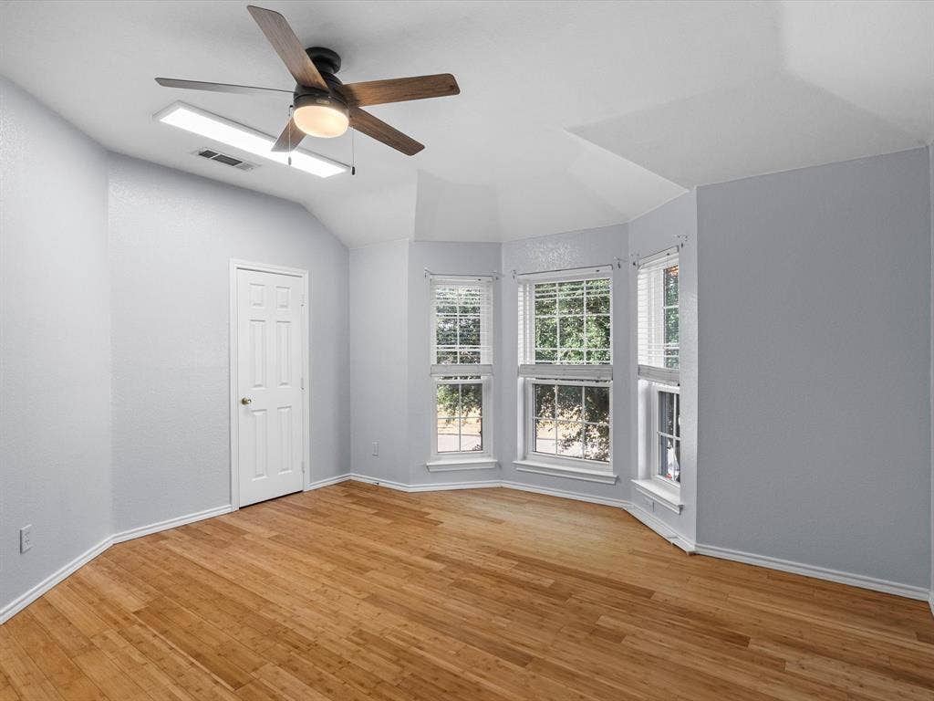 7302 San Carlos Drive, Rowlett, TX 75089 Wood-finish flooring, ceiling fan, multiple windows with blinds, pitched ceiling, and recessed lighting