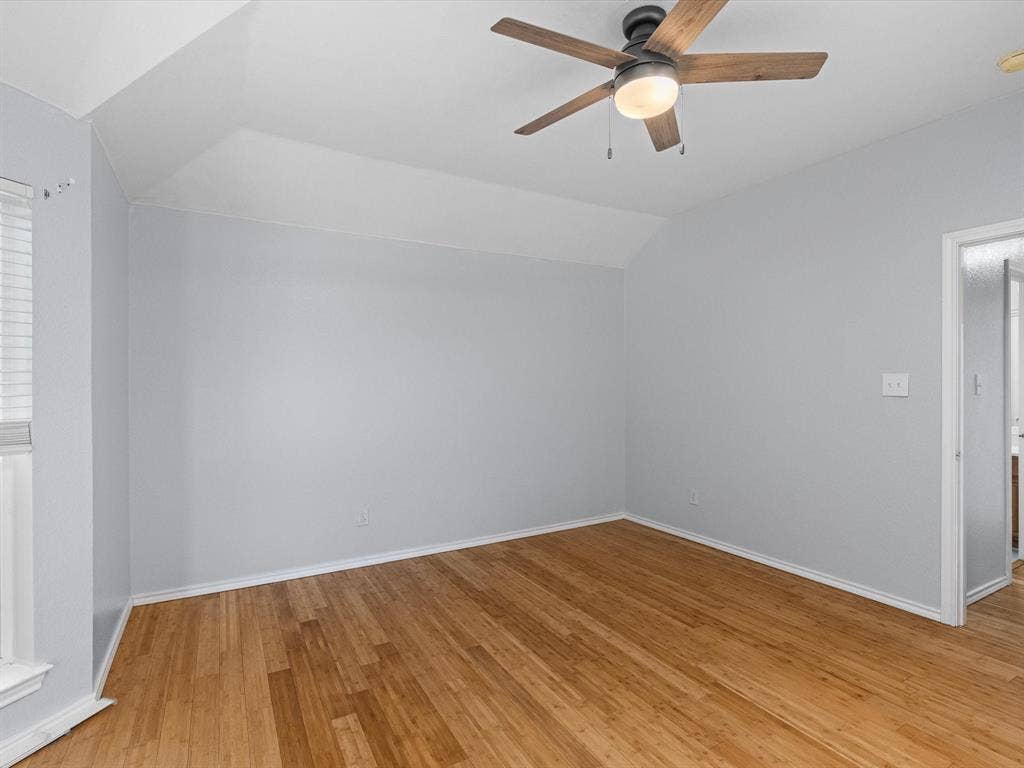 7302 San Carlos Drive, Rowlett, TX 75089 Wood-finish flooring, ceiling fan with integrated lighting, window with blinds, and light-toned walls