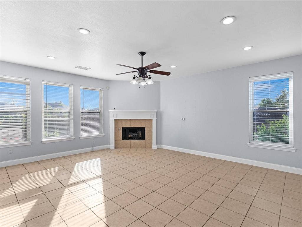 7302 San Carlos Drive, Rowlett, TX 75089 Tile flooring, corner fireplace with tile surround, ceiling fan, and recessed lighting