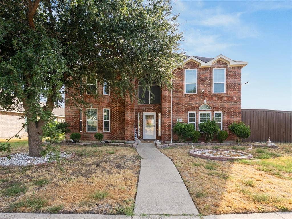 7302 San Carlos Drive, Rowlett, TX 75089 Brick exterior with architectural gables, mature tree, and established landscaping