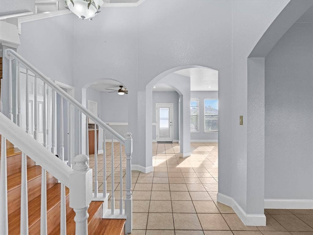 7302 San Carlos Drive, Rowlett, TX 75089 Grand entry with a wood-finish staircase and white balusters