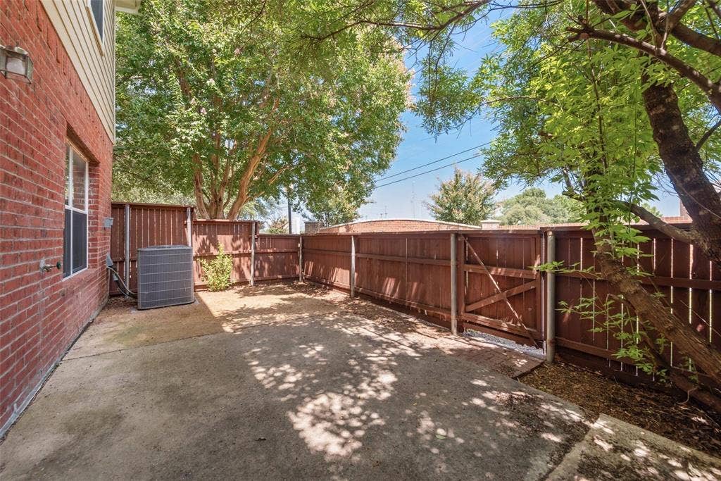 4541 Woodsboro Lane, Plano, TX 75024 Concrete patio area featuring a full privacy fence with a gate