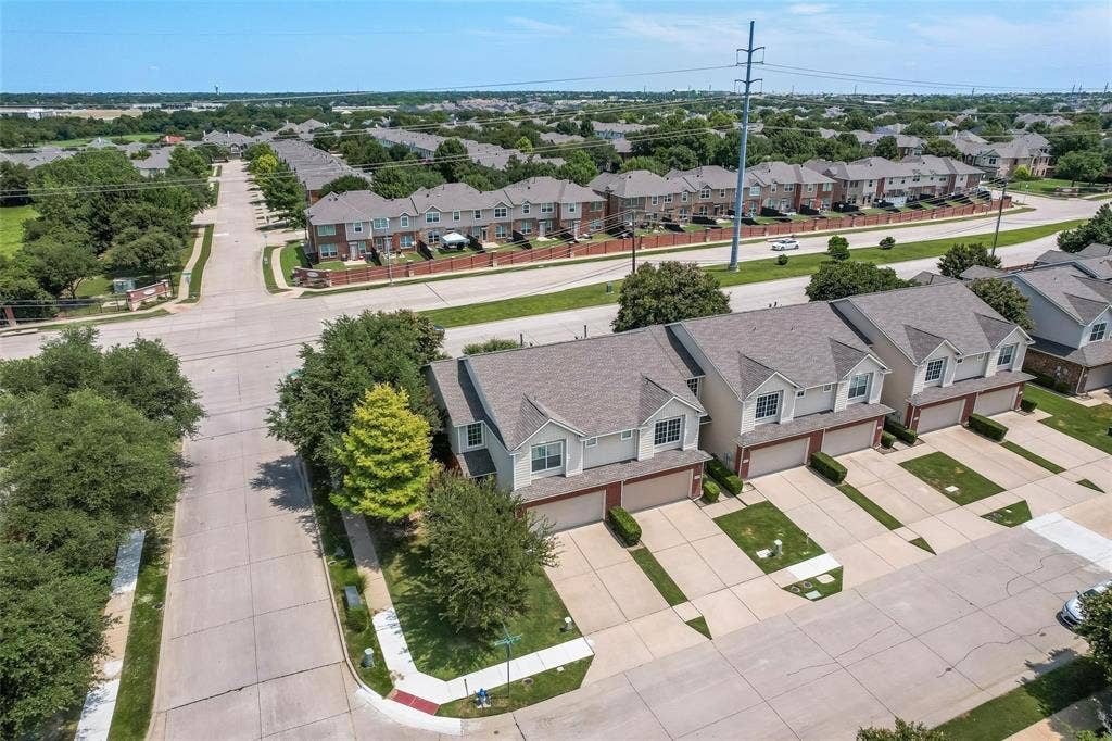 4541 Woodsboro Lane, Plano, TX 75024 Aerial perspective showcasing a residential street, tree-lined sidewalks, and multiple properties with attached garages