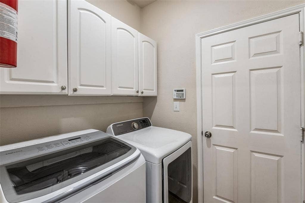 4541 Woodsboro Lane, Plano, TX 75024 White shaker-style cabinetry with curved top panels, white paneled door, and neutral wall paint