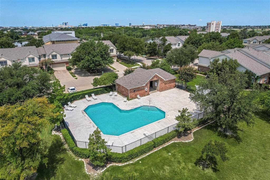 4541 Woodsboro Lane, Plano, TX 75024 Community swimming pool with surrounding concrete decking, brick pool house, and perimeter fencing