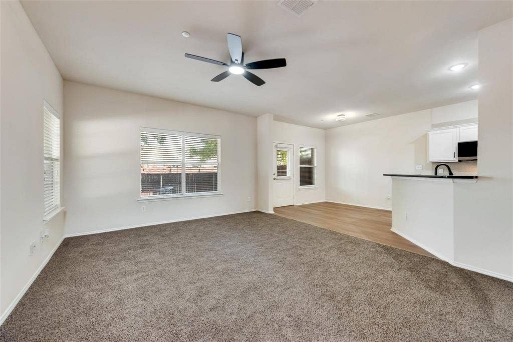 4541 Woodsboro Lane, Plano, TX 75024 Vaulted ceilings with a ceiling fan, dual windows with blinds, wood-finish flooring, and white cabinetry