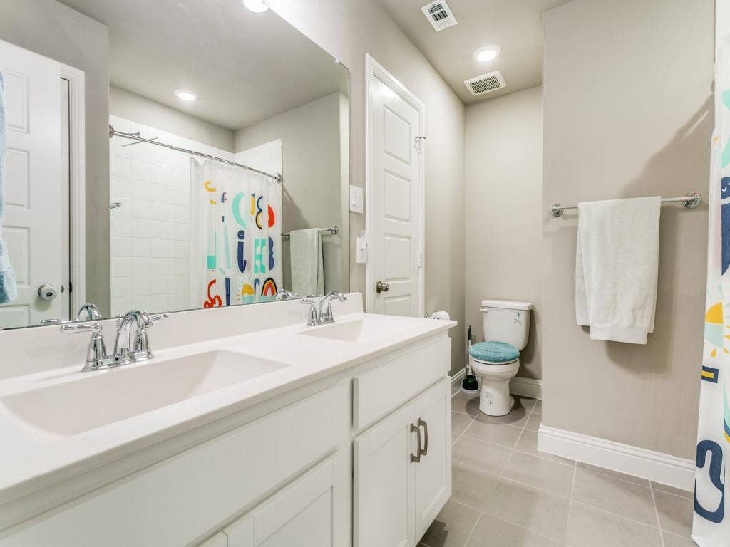 Guest bath upstairs features upgraded granite counters and dual sinks.