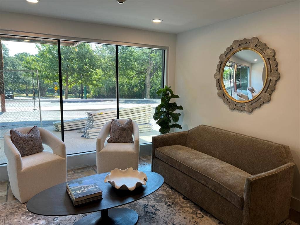 Expansive window wall with natural light, recessed ceiling lighting, and light-toned wall finishes