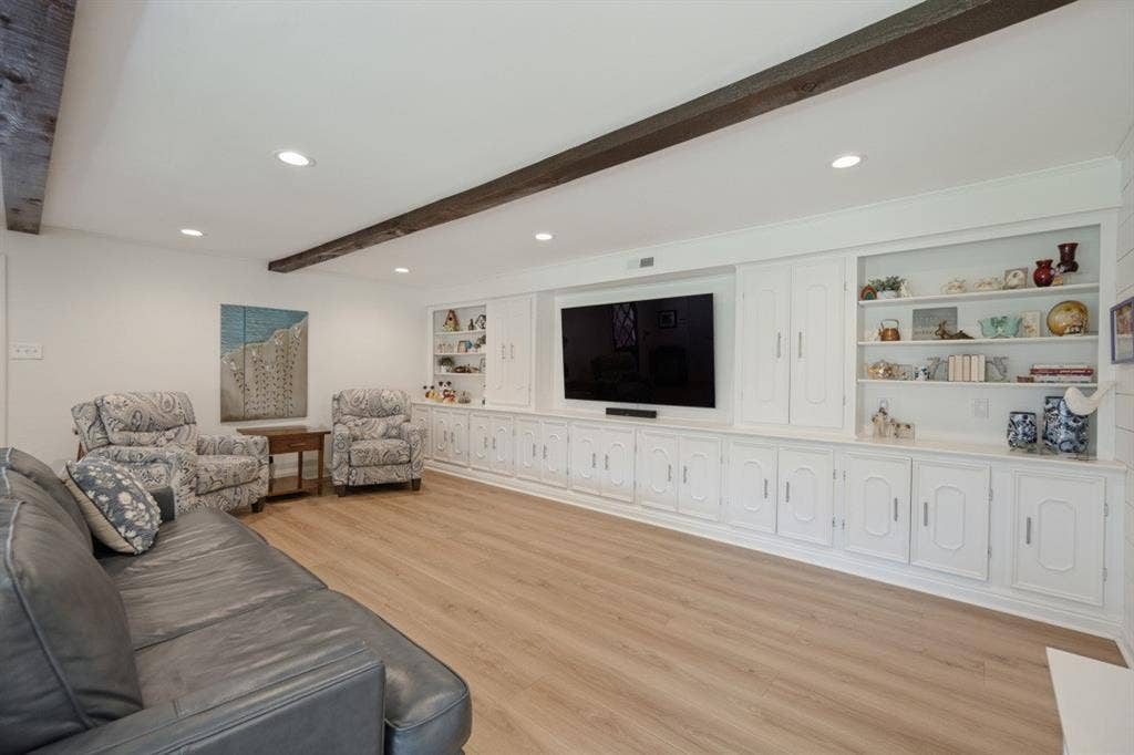 Family Room has a 20 ft wall of built-in cabinets and shelving.  Wooden beams add architectural interest.