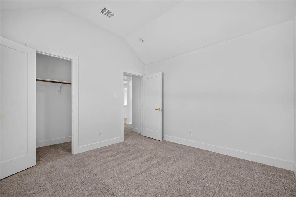 705 N Jordan Road, McKinney, TX 75071 Carpeted flooring, vaulted ceiling, white walls, and a built-in closet with a hanging rod