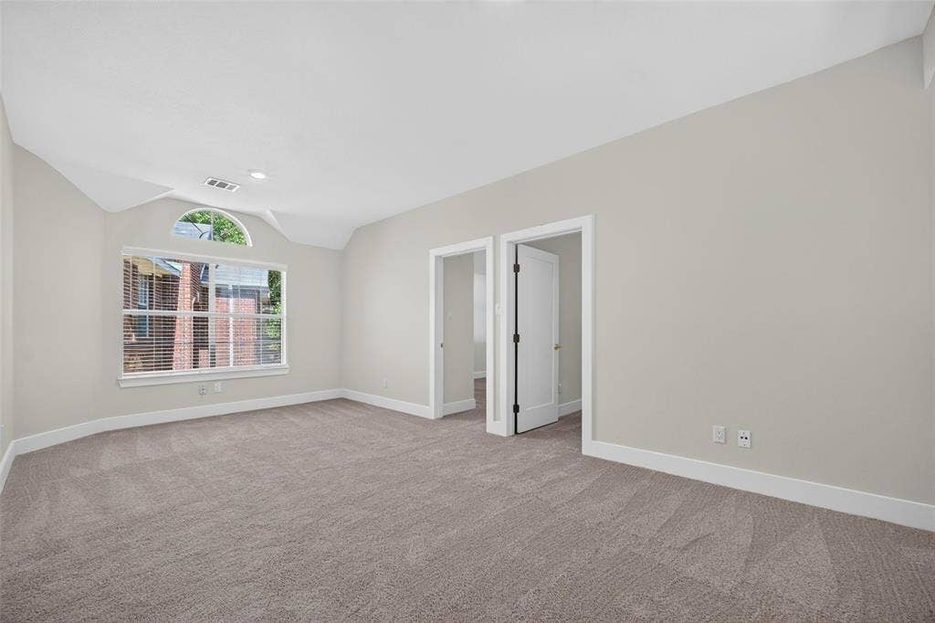 705 N Jordan Road, McKinney, TX 75071 Neutral paint palette with vaulted ceiling, arched window accent, recessed lighting, and soft gray carpet