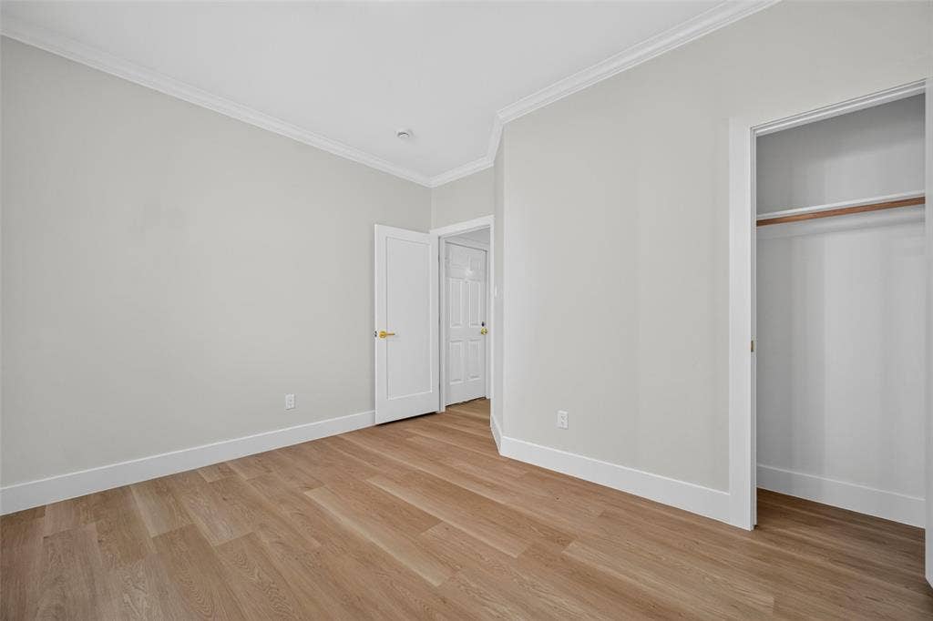 705 N Jordan Road, McKinney, TX 75071 Wood-finish flooring, white baseboards, crown molding, and a built-in closet with a wood rod