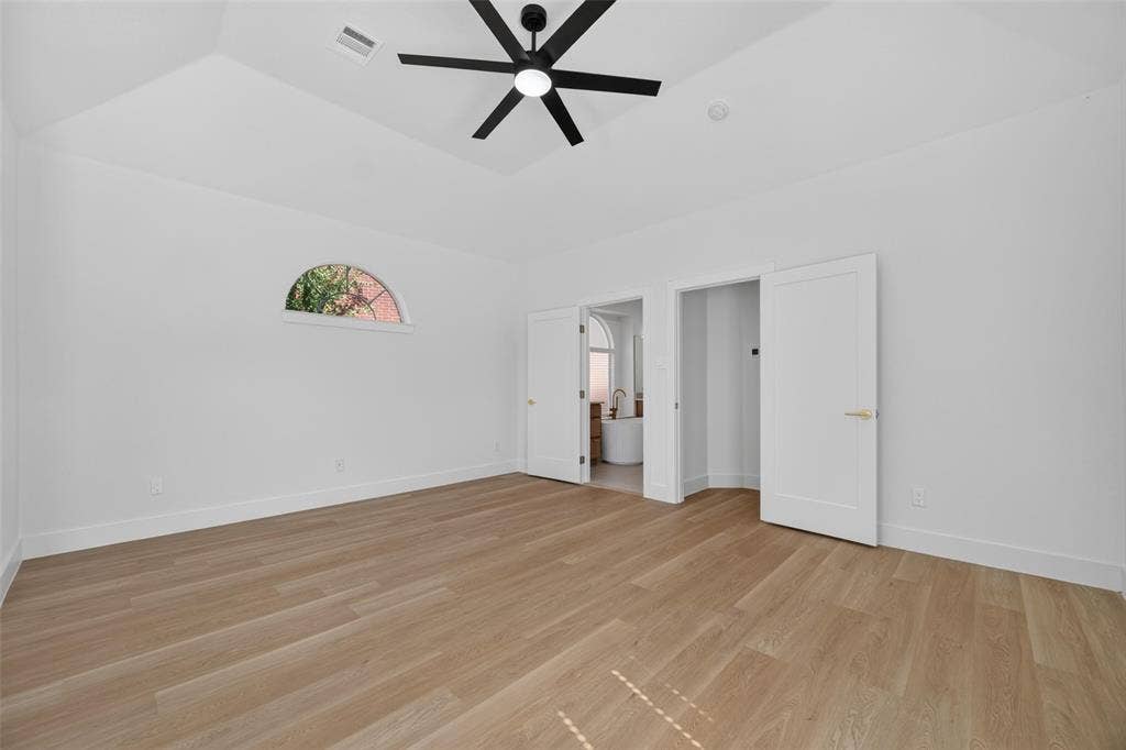 705 N Jordan Road, McKinney, TX 75071 Tray ceiling with a ceiling fan, wood-finish flooring, half-round window, and white interior doors