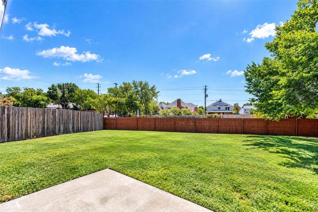 705 N Jordan Road, McKinney, TX 75071 Expansive green space featuring a concrete patio, wood privacy fencing, and mature trees