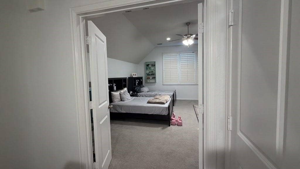 7610 Graystone Drive, Sachse, TX 75048 Room with sloped ceilings, ceiling fan, carpet flooring, and white window shutters