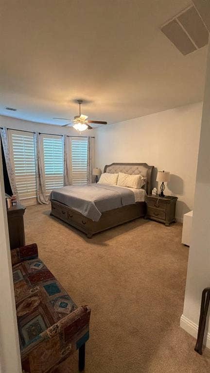 7610 Graystone Drive, Sachse, TX 75048 Carpeted bedroom featuring a ceiling fan with integrated lighting, multiple windows with plantation shutters, and a recessed ceiling speaker