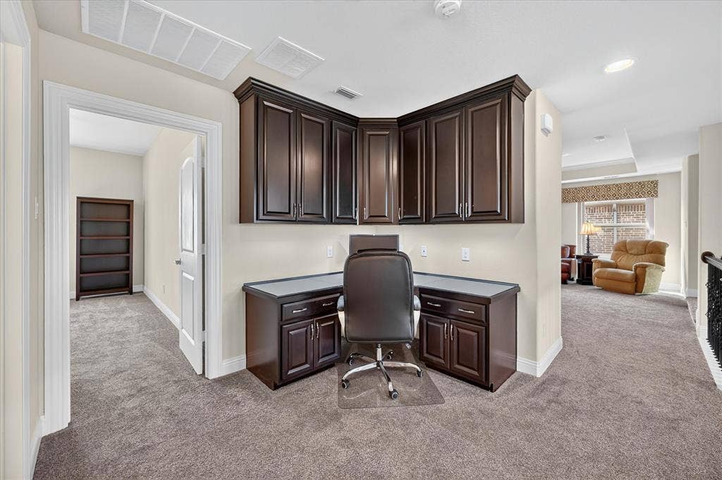Built-in desk area with dark wood-finish cabinetry and gray countertop