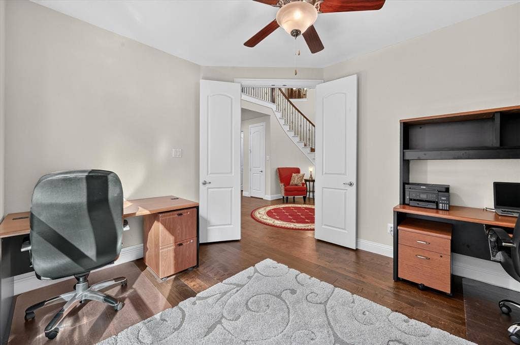 Hardwood flooring, painted walls, ceiling fan with integrated lighting, and white paneled double doors