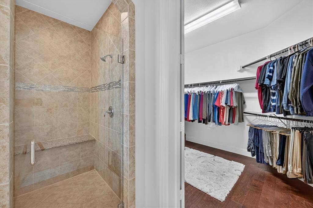 Shower with tiled walls, integrated bench, and mosaic accent band