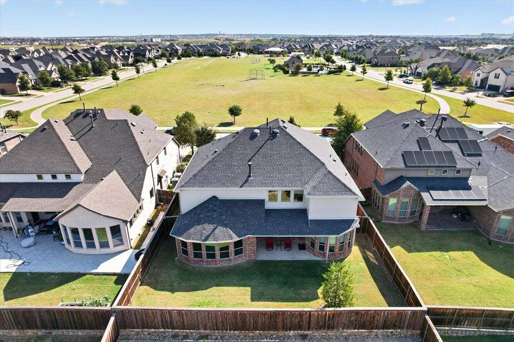 Two-story residence featuring a covered patio, fenced backyard, and a brick and siding exterior