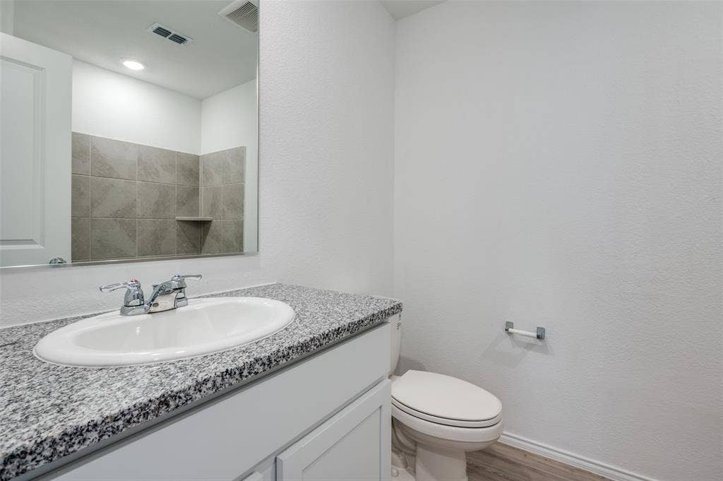 1708 Sims Street, McKinney, TX 75071 Bathroom with toilet, vanity, and hardwood / wood-style flooring