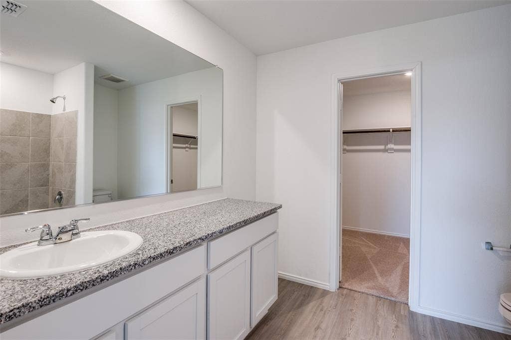 1708 Sims Street, McKinney, TX 75071 Bathroom featuring hardwood / wood-style floors, vanity, toilet, and a shower