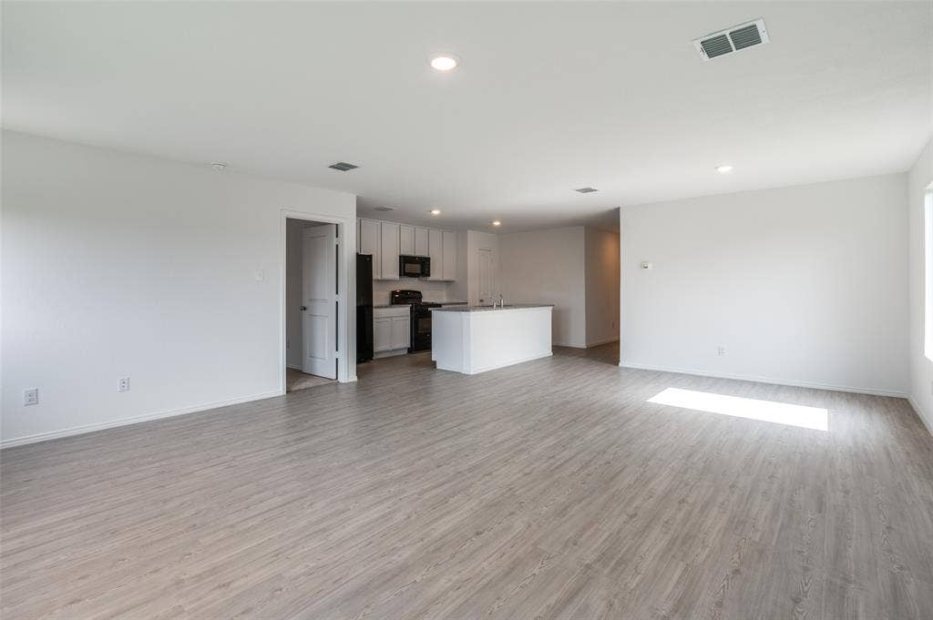1708 Sims Street, McKinney, TX 75071 Unfurnished living room with sink and light hardwood / wood-style floors