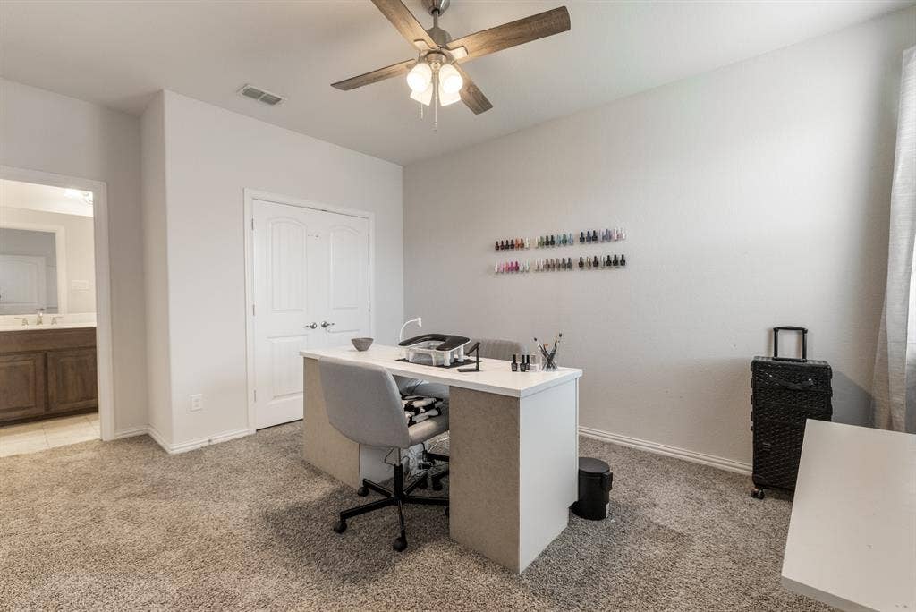 3605 Barby Court, Midlothian, TX 76065 Carpeted room with a ceiling fan, double doors, and a doorway opening to a vanity with wood-finish cabinetry
