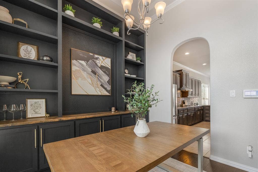 3605 Barby Court, Midlothian, TX 76065 Built-in cabinetry with wood-finish countertop, arched doorway, and overhead chandelier