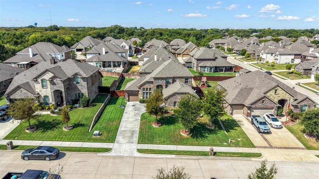 3605 Barby Court, Midlothian, TX 76065 Brick and stone exterior with a gabled roofline, concrete driveway, attached garage, and manicured landscaping