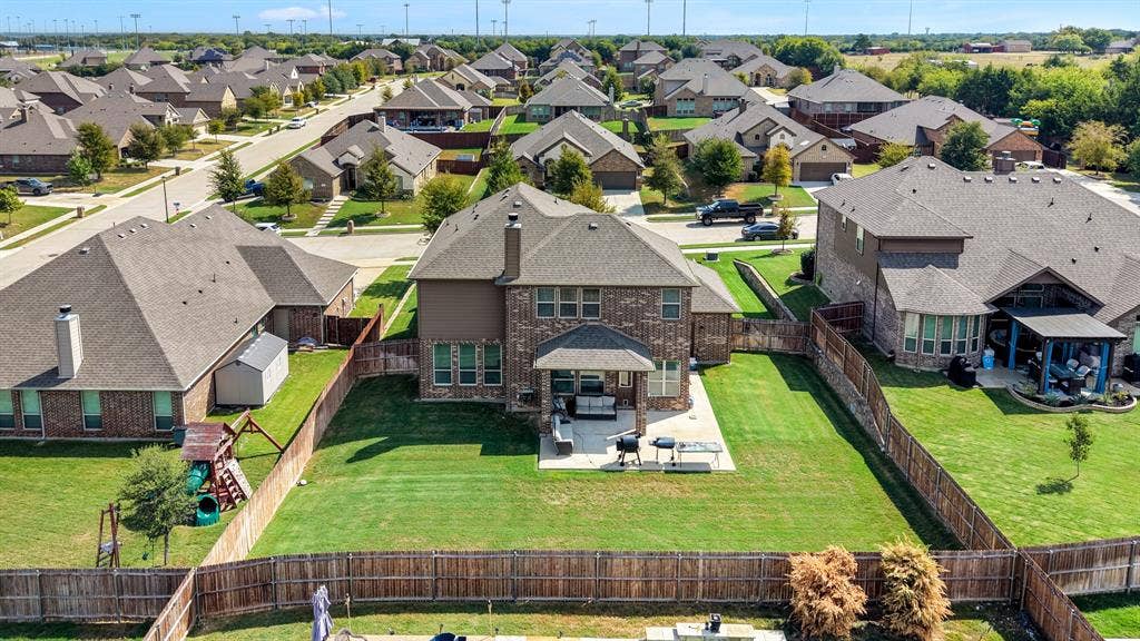 3605 Barby Court, Midlothian, TX 76065 Brick and stone exterior with a covered patio, extensive fenced yard, and well-maintained landscaping