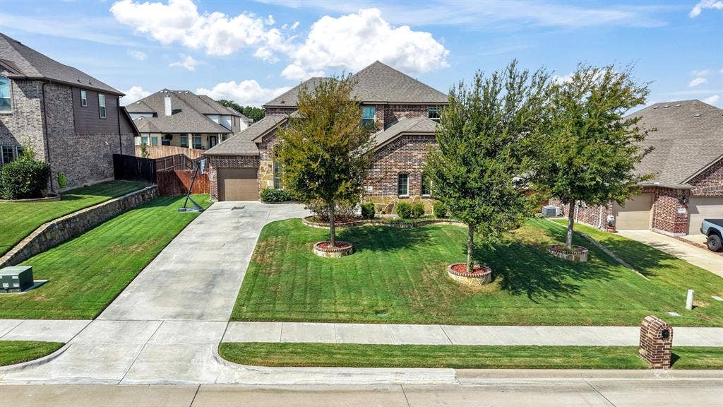 3605 Barby Court, Midlothian, TX 76065 Brick exterior residence with a two-car garage, concrete driveway, and mature landscaping