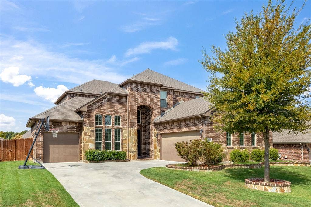 3605 Barby Court, Midlothian, TX 76065 Brick and stone exterior with arched entryway, multi-pane windows, and a two-car garage