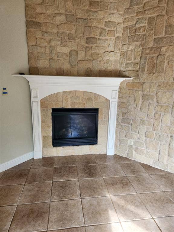 5720 Robbie Road, Plano, TX 75024 Corner fireplace with a stone surround, a white mantel, and a black firebox