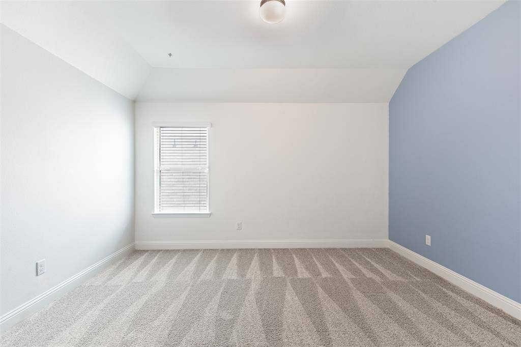 405 Rosie Court, Argyle, TX 76226 Spacious upstairs bedroom, one of three bedrooms on the second floor, featuring generous living space, natural light, and an oversized walk-in closet.