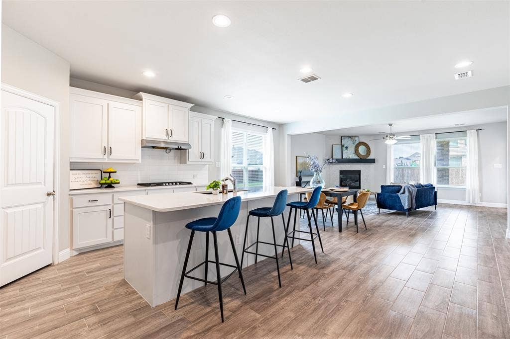 405 Rosie Court, Argyle, TX 76226 Spacious open-concept kitchen, eat-in dining area and living space filled with beautiful natural light and designed for seamless everyday living and entertaining.