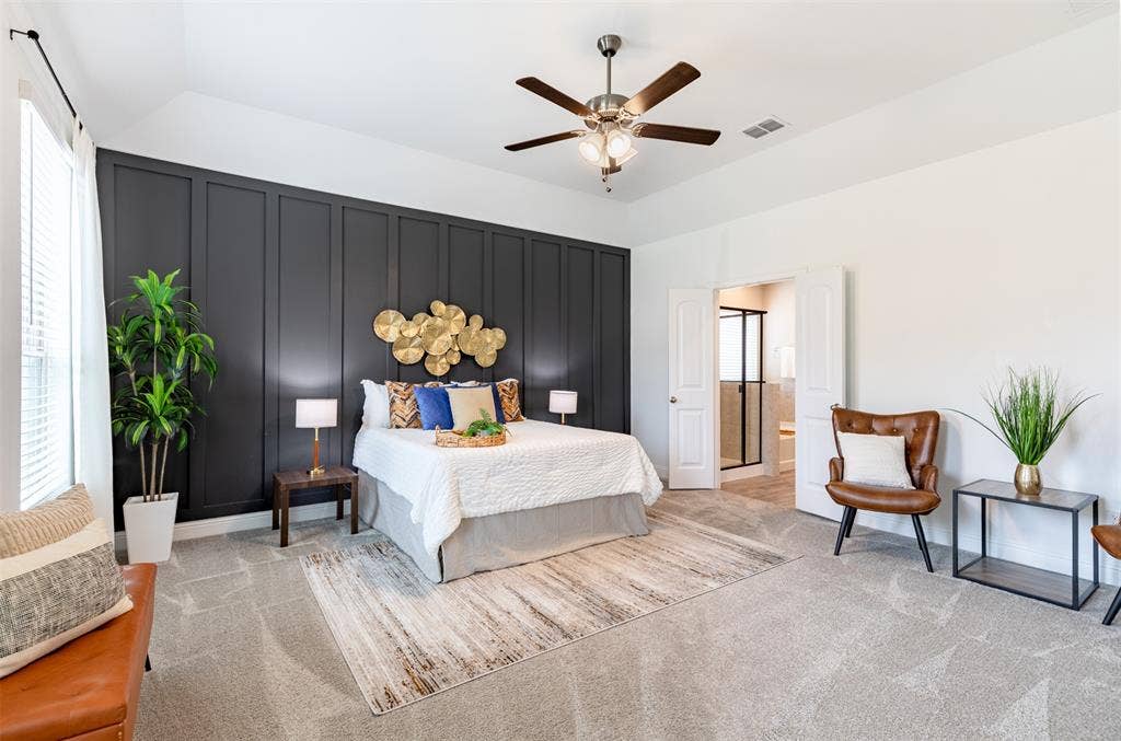 405 Rosie Court, Argyle, TX 76226 Spacious primary suite with large windows, abundant natural light, room for a king-size bed and sitting area, ceiling fan, and a stylish board-and-batten accent wall.