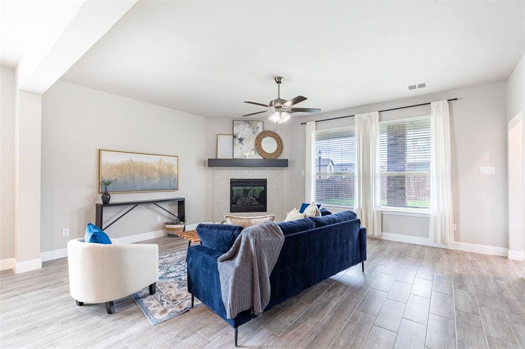 405 Rosie Court, Argyle, TX 76226 Spacious living room with a gas fireplace and log insert, cable TV hookup, and large windows overlooking the backyard with abundant natural light.