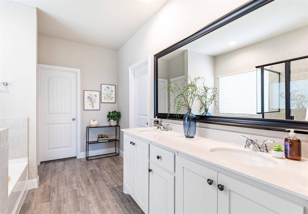 405 Rosie Court, Argyle, TX 76226 Primary bathroom featuring a spacious double vanity with ample storage and access to two oversized walk-in closets for exceptional storage and organization.